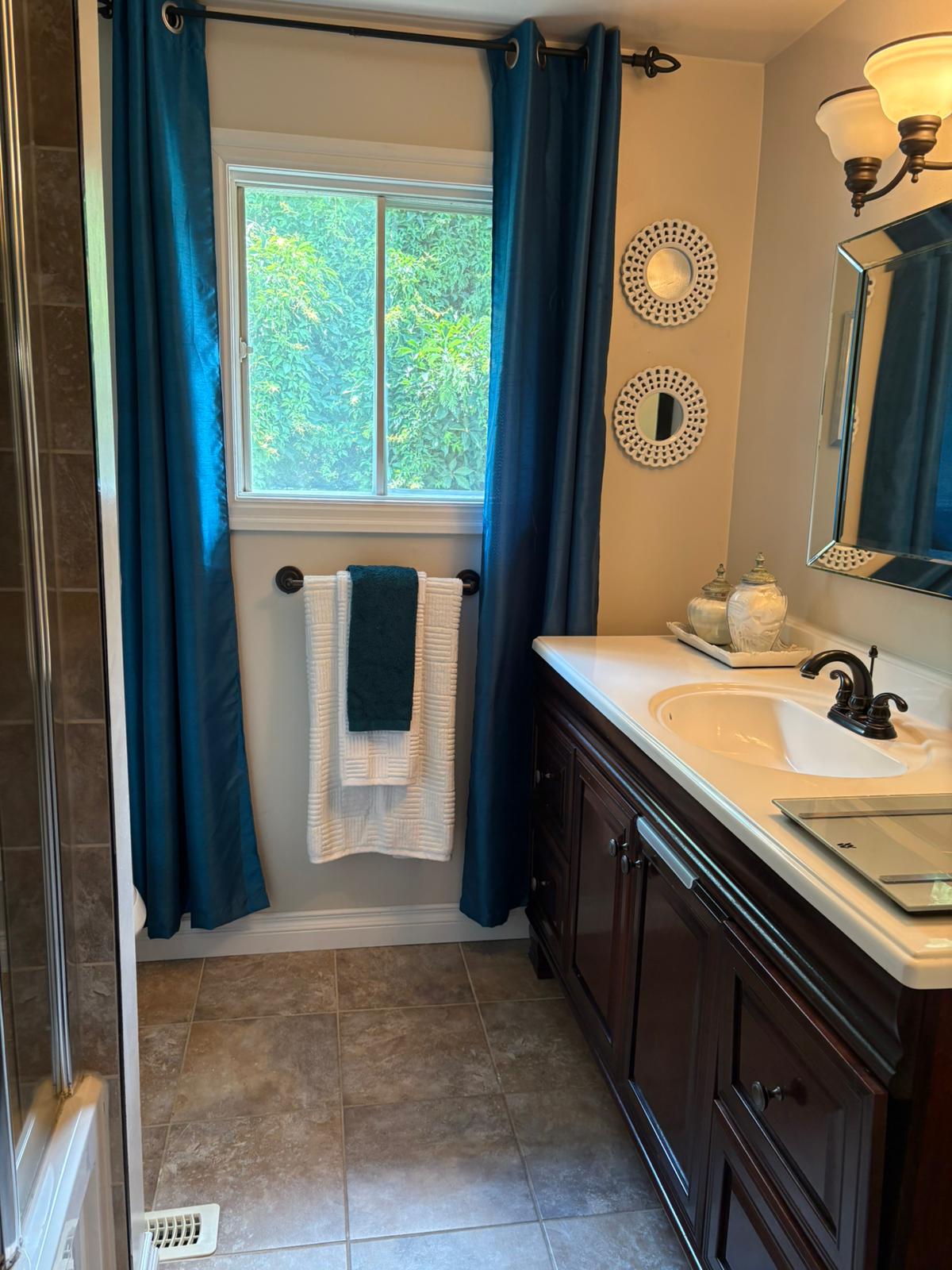 Clean bathroom with blue curtains in Markham home